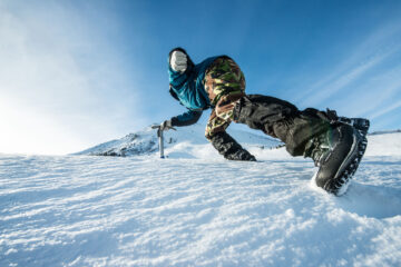 Close up of ice climbing boots on an icy mountain.